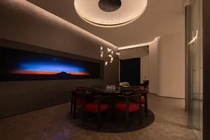 A modern dining room with marble furniture and a large, illuminated artwork on the wall.