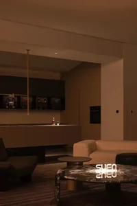 現代客廳擺放深色皮革沙發，搭配黑色大理石裝飾細節。