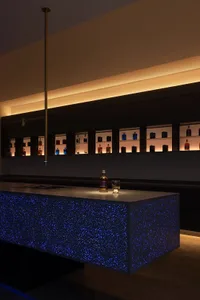 Contemporary bar counter with blue backlighting and metallic finish.