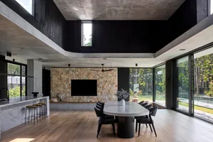 A modern living room with a stone fireplace, concrete ceiling, and marble floor.