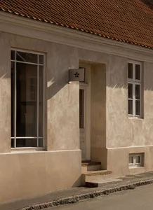 A modern building with a light brown cement exterior features clean lines and minimalistic design, showcasing contemporary ar