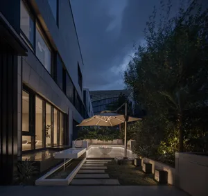 A modern residential patio featuring concrete flooring and landscaping.