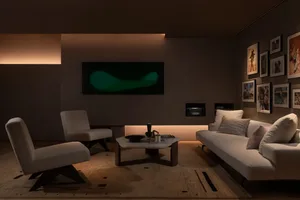 A cozy modern living room with white furniture, a flat-screen TV, and a modern art piece on the wall.