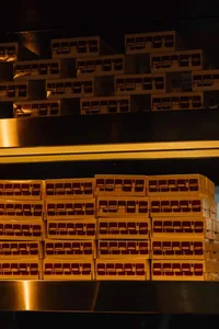 Stacked cardboard boxes with red text on a reflective surface.