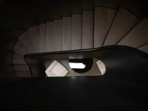 A modern interior staircase with wooden steps and a curved design.