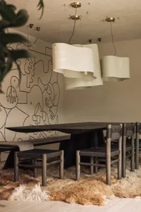 A modern dining room featuring wooden furniture, including a long dining table and chairs.