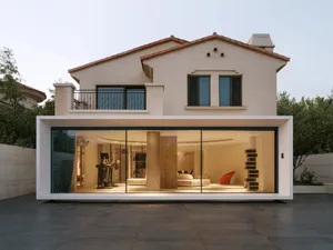 A modern residential exterior featuring a white building with a flat roof and large windows.
