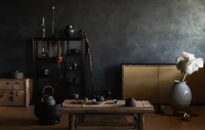 A rustic living room with dark industrial decor, featuring wooden furniture and aged objects.