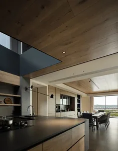 Modern minimalist kitchen with black countertops, wooden cabinets, and large windows.