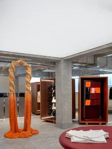 A modern retail store interior featuring wooden shelves, concrete walls, and glass display cases.