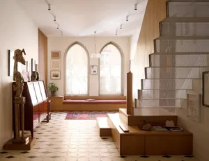 A modern living room featuring wooden and metallic elements, a textile-covered seating area, and a plaster staircase.