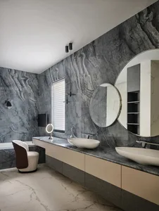 A modern bathroom featuring marble walls and a floating vanity with double sinks.
