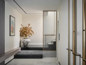 A modern entrance featuring a marble step, concrete floor, and brass frame.