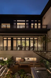Modern residential interior featuring wooden furniture, glass windows, and metallic accents.