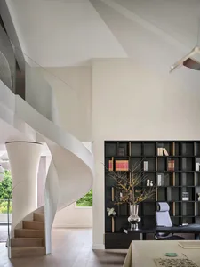 An elegant, minimalist home office and library interior with white spiral stairs and a sophisticated bookshelf.