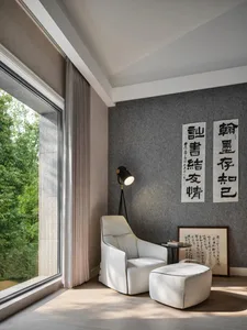 Modern minimalist living room featuring a sofa, floor lamp, and framed artwork with Chinese calligraphy.