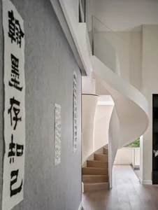 A modern staircase with wooden steps and white railings.