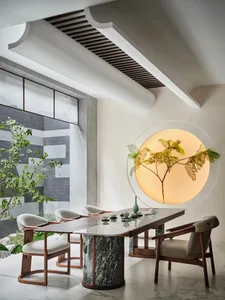 Tea room with modern design featuring marble table and wooden chairs.