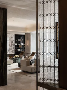 Modern living room with marble walls, leather furniture, and metal accents.