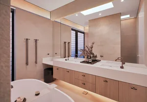 A modern bathroom featuring porcelain tiles, a double sink vanity, and a freestanding bathtub.