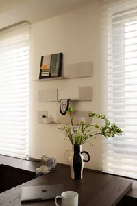 A minimalist interior design featuring a wooden desk with a ceramic figurine and modern decor elements.