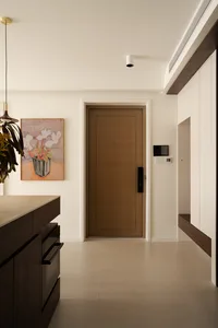 A modern residential entry featuring a wooden door and ceramic tiled floor.