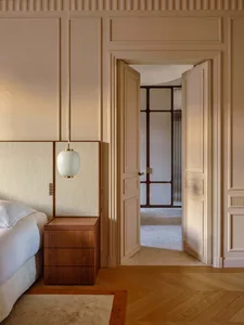 Minimalist bedroom with soft wood accents, glass elements, and textured textiles.