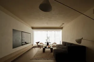A minimalist living room with neutral-toned walls, a dark sofa, and a low coffee table.