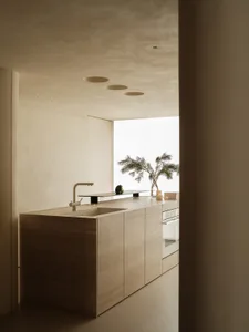 A modern residential kitchen featuring minimalist design with concrete countertops and flooring.