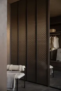 Modern minimalist closet with dark wooden cabinetry and a white cushioned bench.