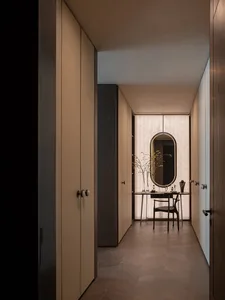 A modern, minimalist closet with wooden cabinets and a table.