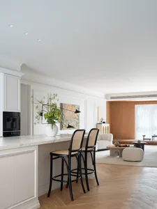A minimalist living, dining, and kitchen space with modern materials and a cohesive design.
