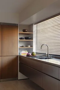 Modern kitchen with stainless steel countertops, wooden cabinets, and metal fixtures.