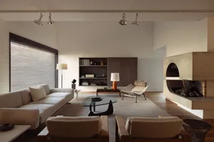 A minimalist living room featuring concrete, wood, and glass materials.