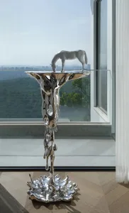 A modern metal sculpture depicting a horse on a pedestal with a flowing, abstract design.