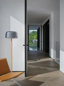 Hallway with a modern design featuring wood flooring and glass doors leading to a garden.