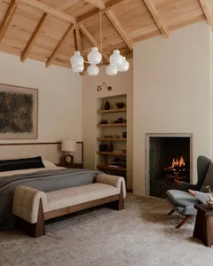 A minimalist bedroom with wood elements and a fireplace.
