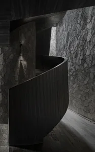 A modern black staircase with wooden railings.