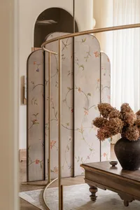 Modern, stylish divider screen with floral patterns in a living room setting.