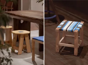 Wooden stools with a strap seat, set against a wooden table and tiled floor, showcasing a simple and rustic design.