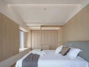 Modern bedroom with wooden walls and a large bed.