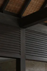 A close-up view of dark wooden ceiling beams with a textured, natural finish.