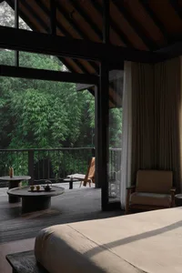 A modern residential bedroom featuring wood finishes and a view of a dense forest.