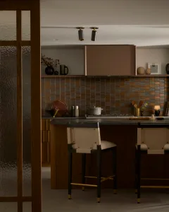 Modern residential kitchen with wood cabinets, metal accents, and stone countertops.