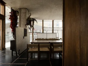 Modern dining room with wooden tables and chairs.