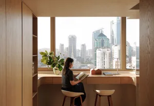 A person seated at a wooden desk in a modern office environment, overlooking a city skyline.