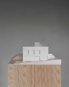 Ein Miniaturmodell eines modernen Hauses aus Papier mit konstruktiven Einzelheiten und Schritten.