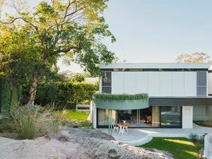 Modern residential exterior featuring concrete, glass, and metal elements.