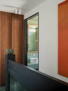 A modern bathroom with blue tiles and wooden elements.