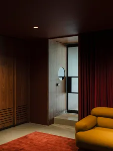 Modern industrial office space featuring wooden door and red curtains.